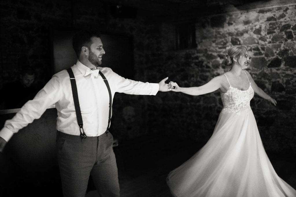 Schwarzwei&szlig; Hochzeitsfotografie von gro&szlig;en Moment auf der Hochzeitsfeier und Party eines Brautpaars, dem Hochzeitstanz in schickem Brautkleid und Anzug im Rahmen einer Hochzeit. Sie feiern in einer sch&ouml;nen Location in Hanau in der N&auml;he von Frankfurt am Main. Sie genie&szlig;en ihren besonderen Tag