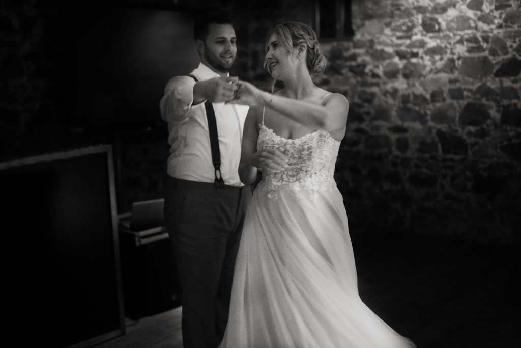 Schwarzwei&szlig; Hochzeitsfotografie von gro&szlig;en Moment auf der Hochzeitsfeier und Party eines Brautpaars, dem Hochzeitstanz in schickem Brautkleid und Anzug im Rahmen einer Hochzeit. Sie feiern in einer sch&ouml;nen Location in Hanau in der N&auml;he von Frankfurt am Main. Sie genie&szlig;en ihren besonderen Tag