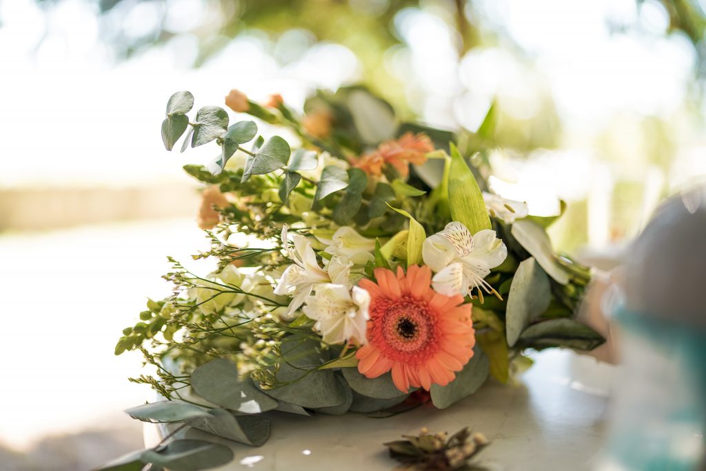 Hochzeitsfotografie von der standesamtlichen Trauung eines Brautpaars in schickem Brautkleid und Anzug im Rahmen einer Hochzeit. Die Sonne scheint in der Natur auf der Burg von Kronberg im Taunus in der N&auml;he von Frankfurt am Main. Sie steckt ihrem Mann den Ehering an die Hand und der steckt ihr den Ring an ihre Hand. Neben ihnen sitzen ihre Trauzeugen. Die Standesbeamte sitzt vor ihnen. Sie haben einen sch&ouml;nen Ausblick auf die Altstadt und den Taunus. Hinter ihnen sitzen ihre Familien. Sie haben viel Spa&szlig; auf ihrer Hochzeitsfeier und Party.
