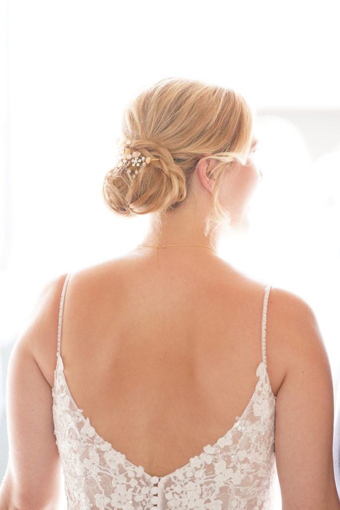 Hochtzeitsfotografie-Braut-glücklich-Kleid-Sonne-Schön-Brautkleid-Kirche-Frankfurt Hochzeitsfotografie einer jungen attraktiven Frau im Rahmen einer Hochzeit als Braut. Die Sonne scheint ihr ins Gesicht während sie aus der Kirche von Hanau in der Nähe von Frankfurt am Main kommt. Sie trägt ein schickes Brautkleid