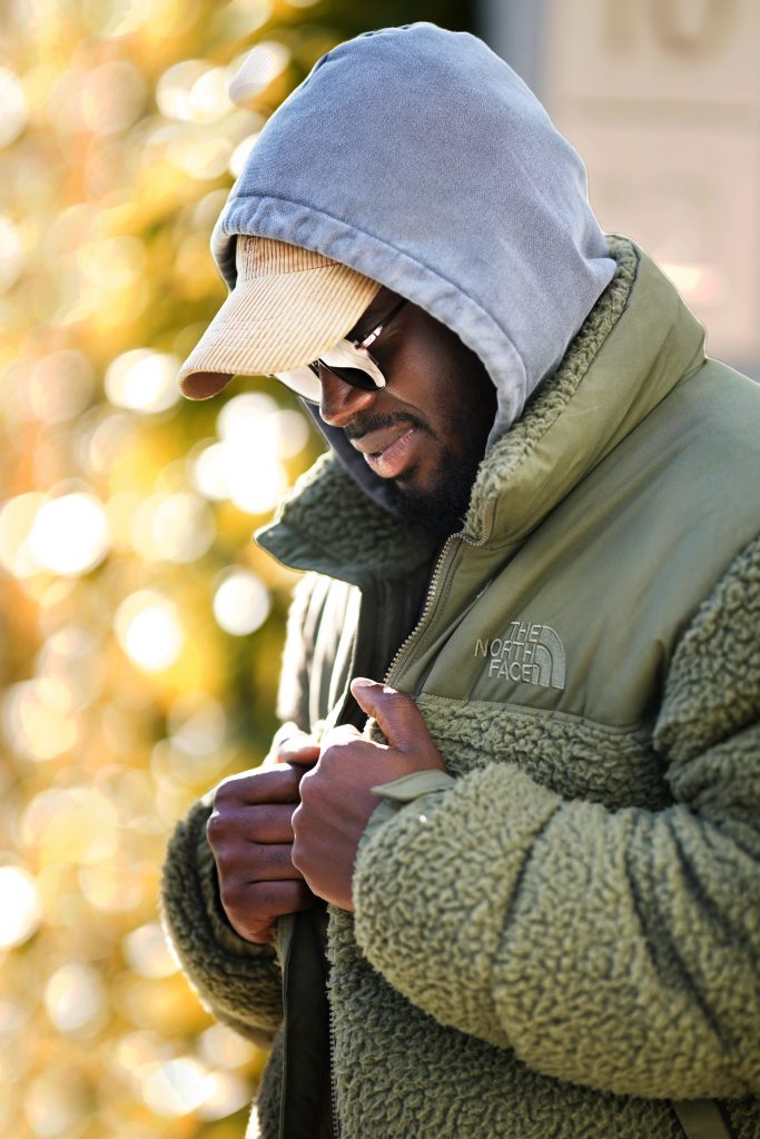 Street-Fotografie von jungen modischen Mann in Northface Jacke in der Frankfurter Innenstadt im Sonnenschein